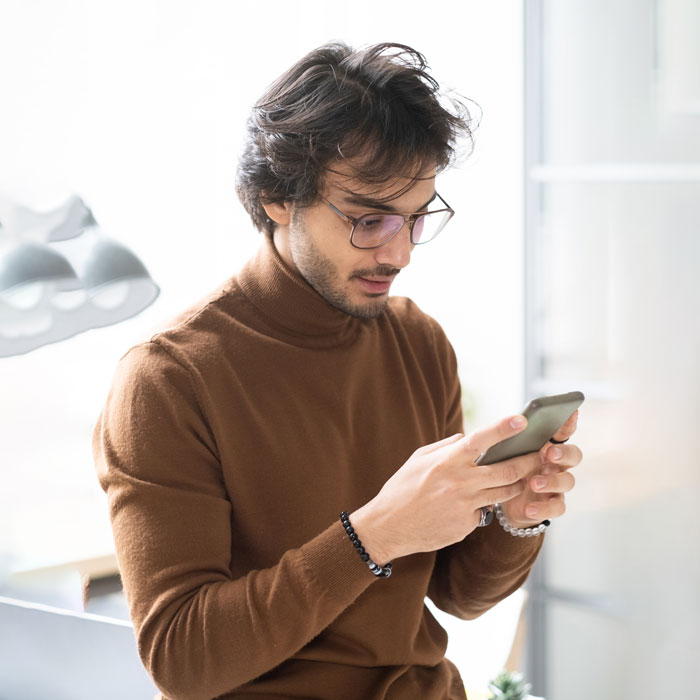 A group of people happily talking around a laptop, suggesting a collaborative learning or work environment.