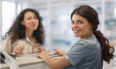 A woman in a medical uniform smiling in a group.