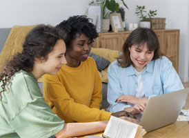 A woman in a medical uniform smiling in a group.