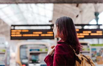 Woman holding books near a whiteboard