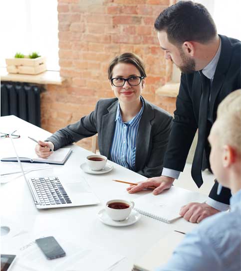 A group of people collaborating around a table in a modern office.