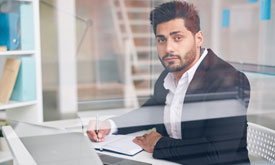 Traveller with suitcase at airport window, representing new journeys and global opportunities with Berlitz.