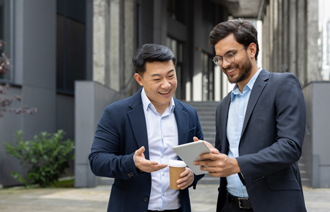 Two people laughing and dining outside at sunset.